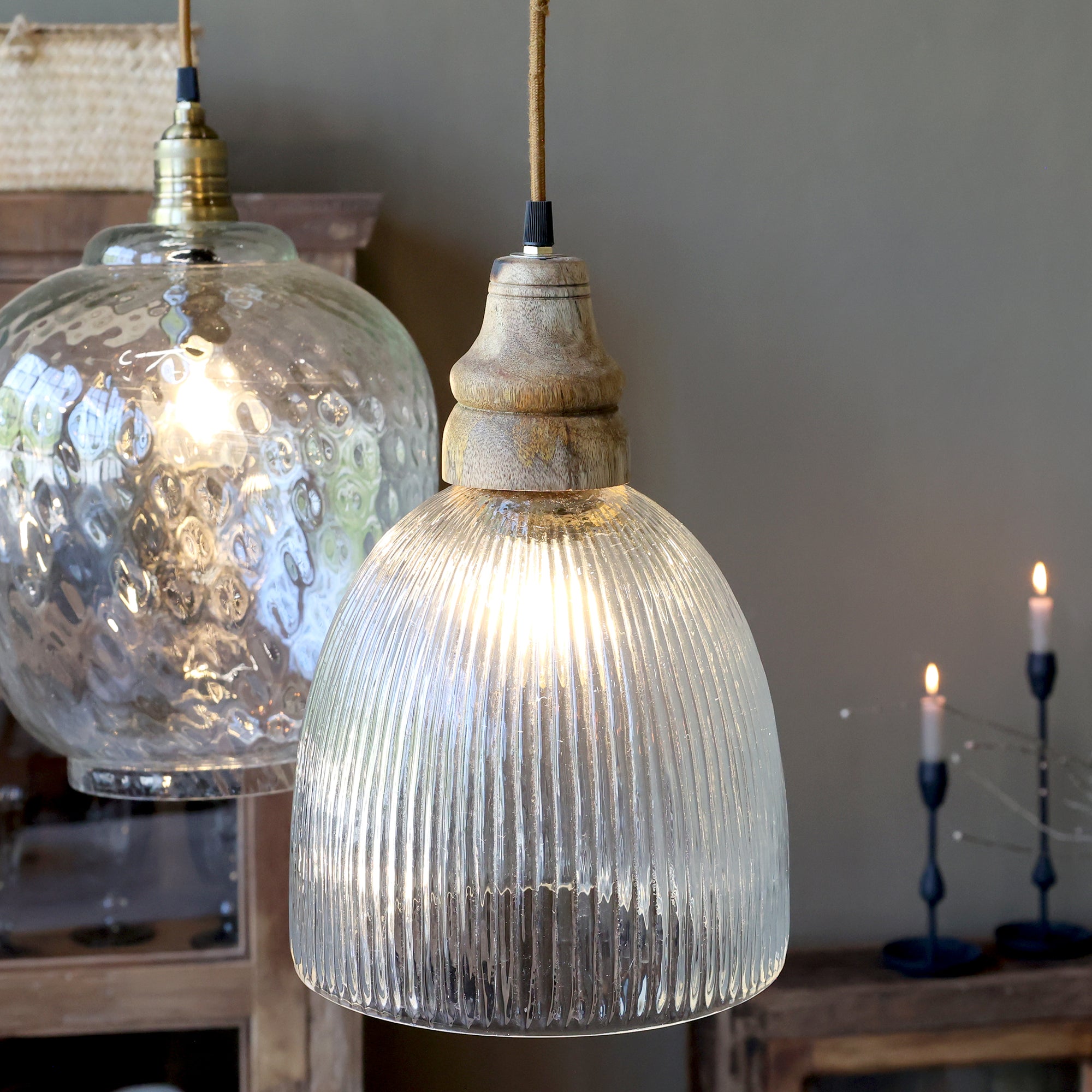 fluted glass pendant light displayed alongside another pendant ceiling light in a hallway against a grey wall