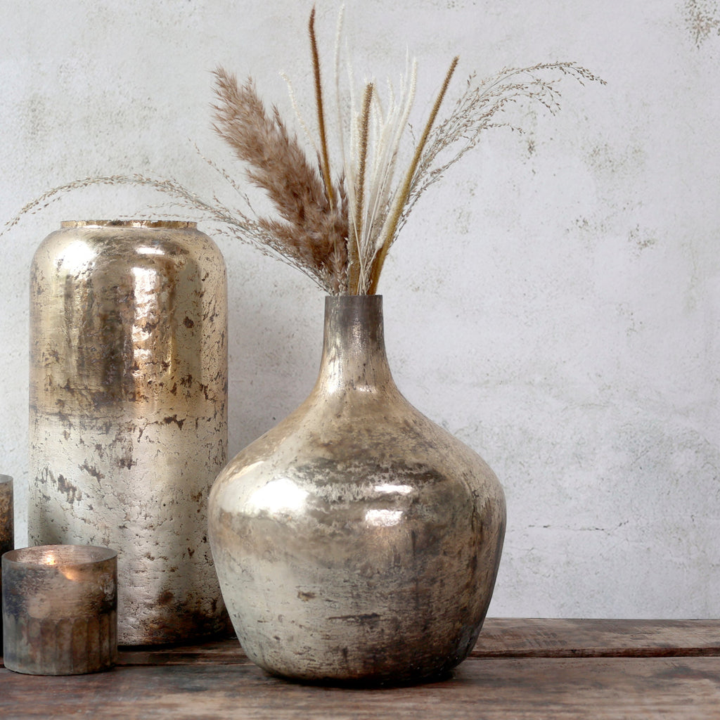 decorative gold and bronze balloon vase on a wooden surface against a neutral wall