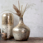decorative gold and bronze balloon vase on a wooden surface against a neutral wall