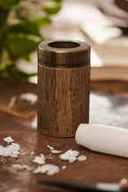 wooden candle sharpener sat on a wooden surface against a neutral background
