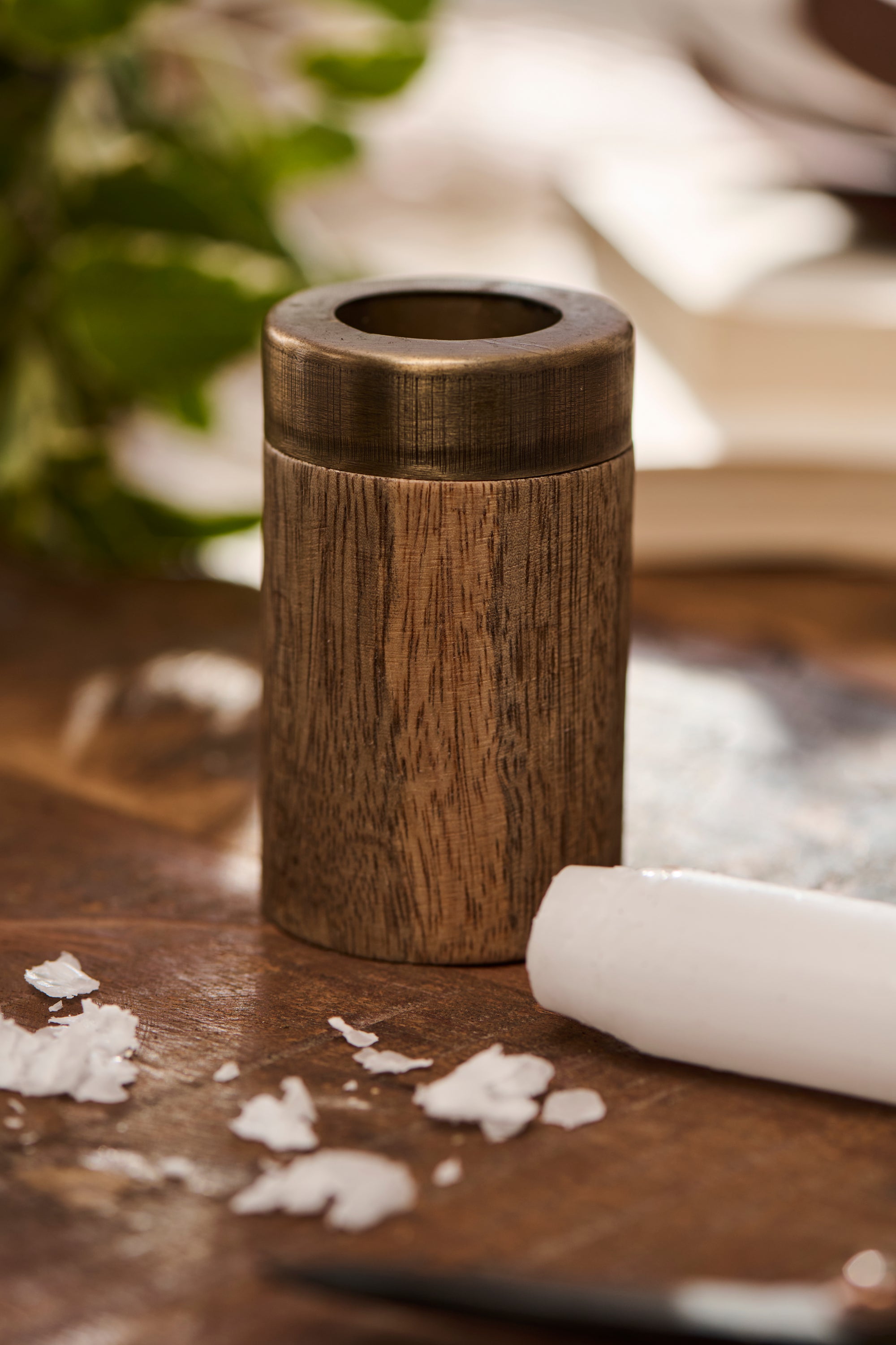 wooden candle sharpener sat on a wooden surface against a neutral background